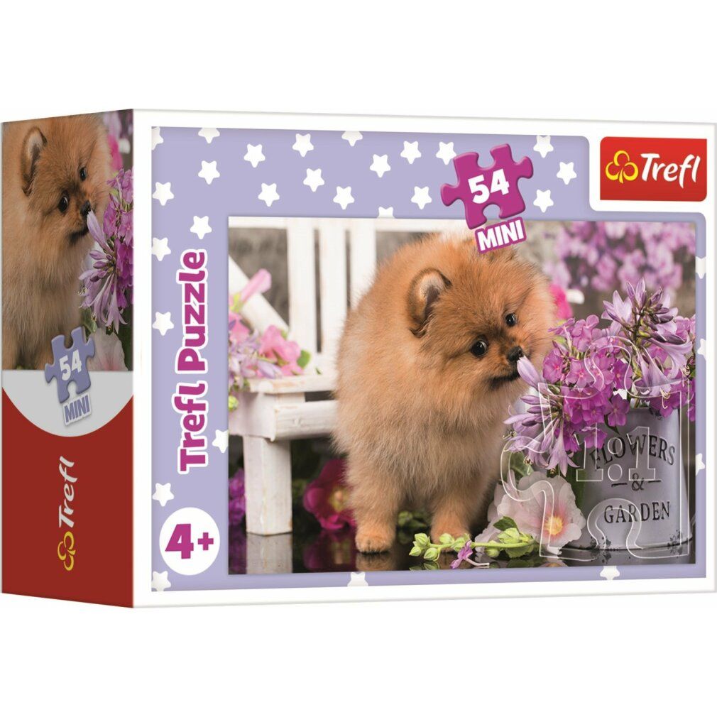 Scatola di puzzle con un cagnolino marrone. Sulla scatola c'è scritto "Trefl Puzzle" e "54 MINI". L'immagine mostra il cane davanti ai fiori.