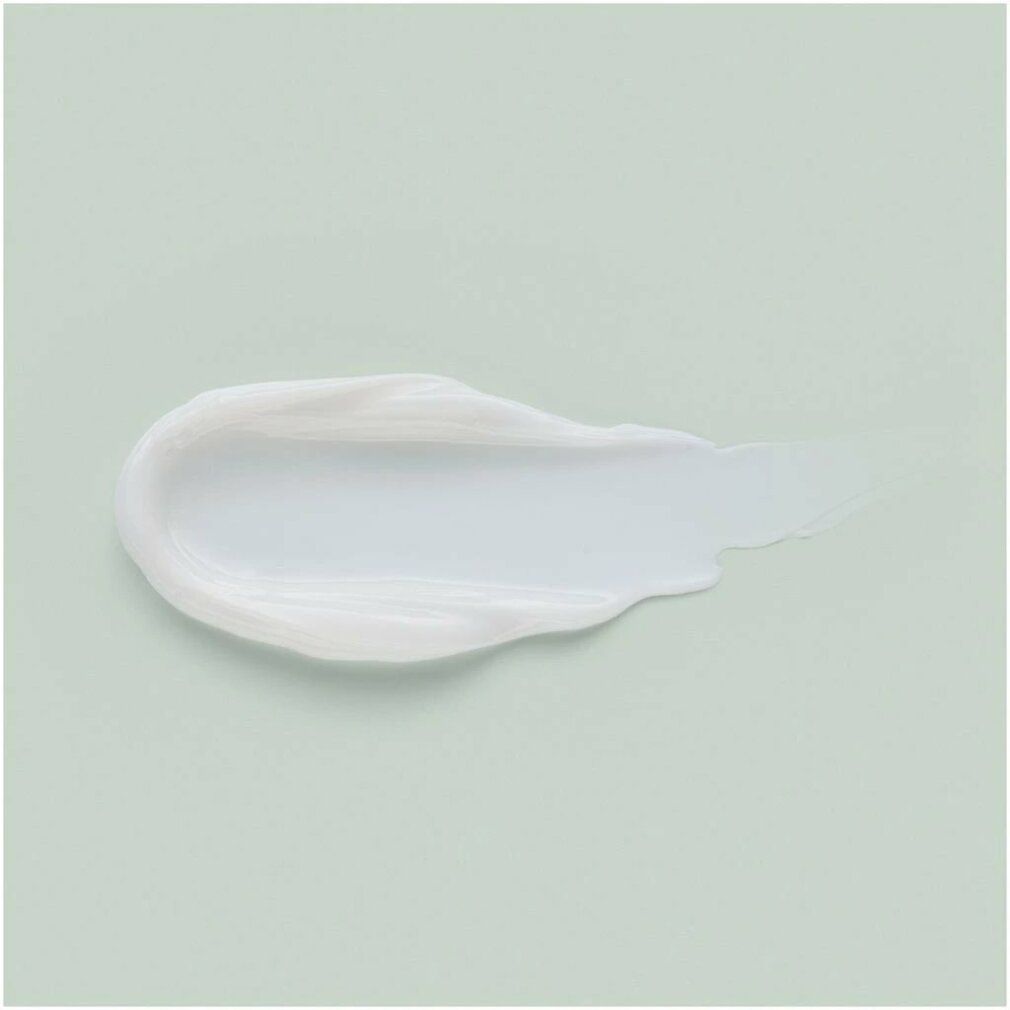 Traccia di crema bianca su sfondo verde chiaro.