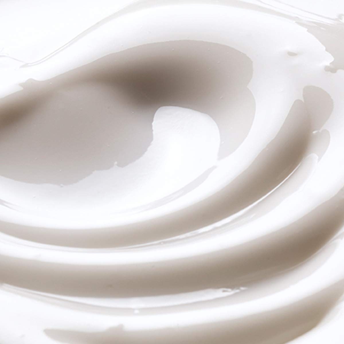 Primo piano di crema bianca cremosa con texture ondulate. Superficie lucida.