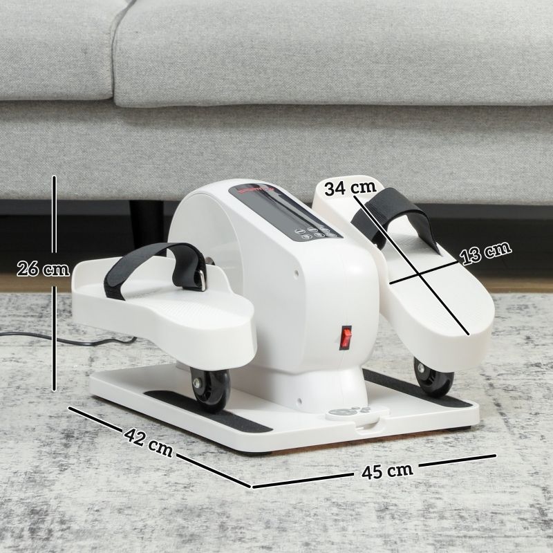 Mini ellittica bianca, cinghie nere, dimensioni 45x42x26 cm. Pulsante on/off rosso, ruote. Su tappeto, davanti al divano.