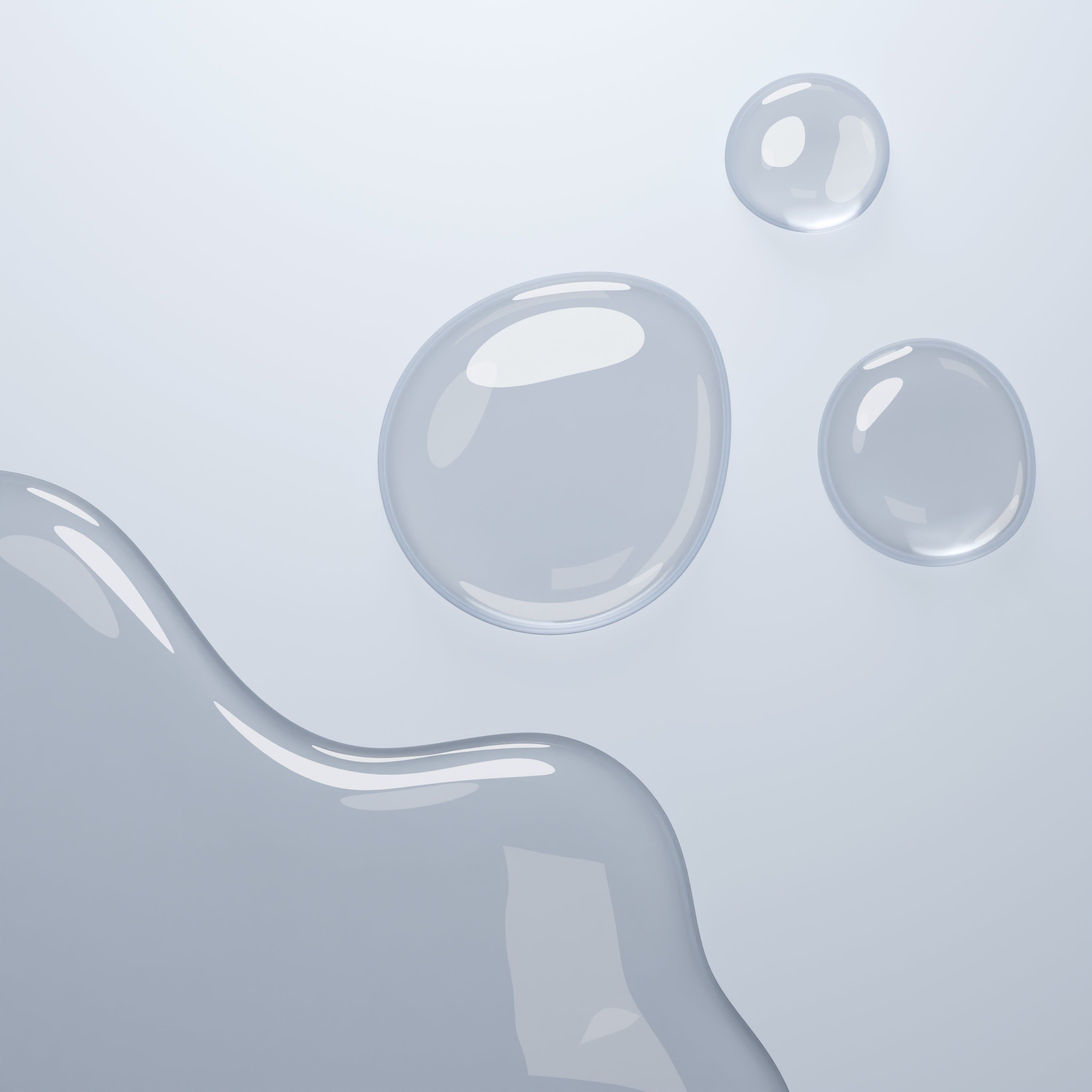 Tre gocce di liquido su sfondo chiaro. Forme rotonde e ovali.