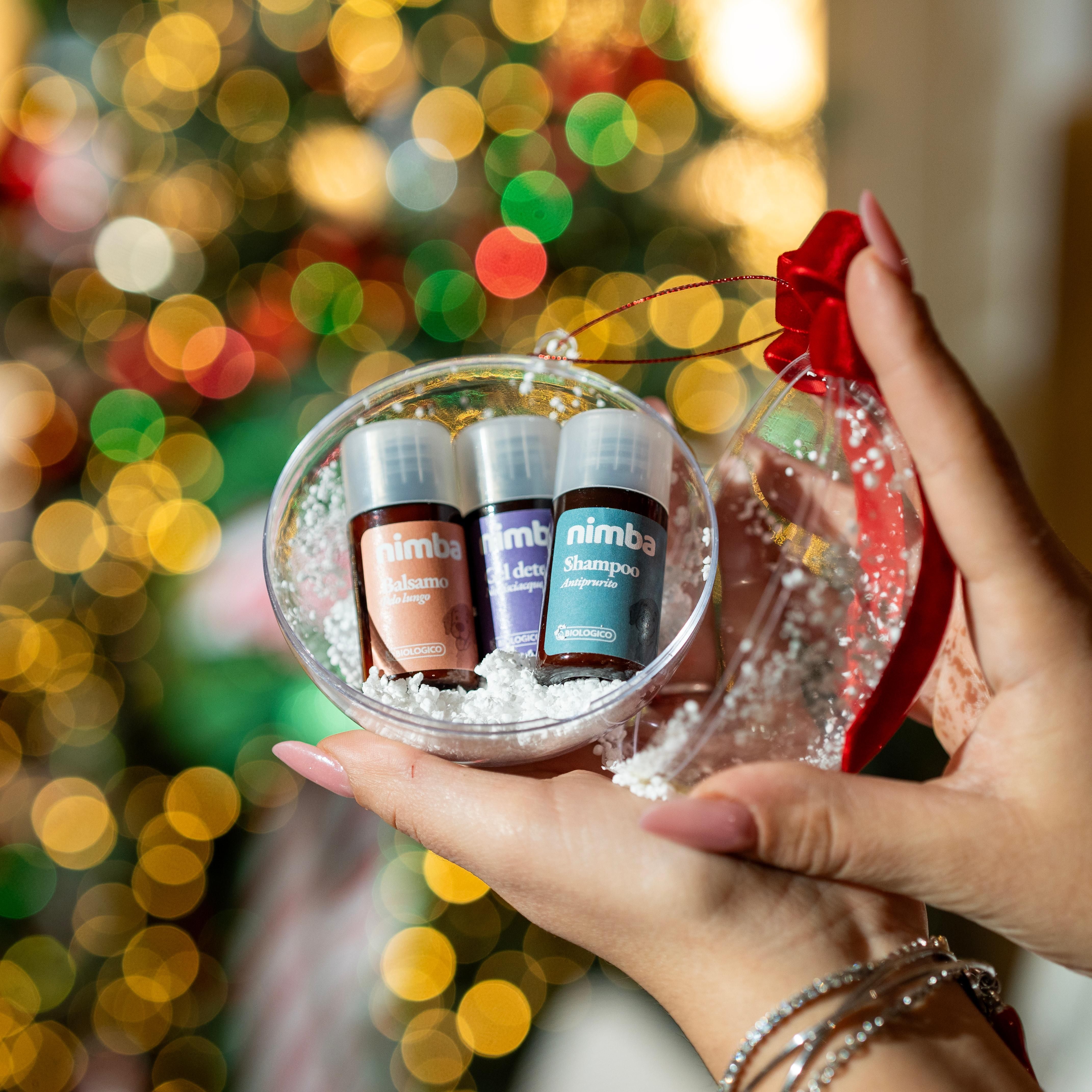 Tre piccole bottiglie in una sfera trasparente. Su ogni bottiglia c'è scritto « nimba ». La sfera è tenuta in mano.