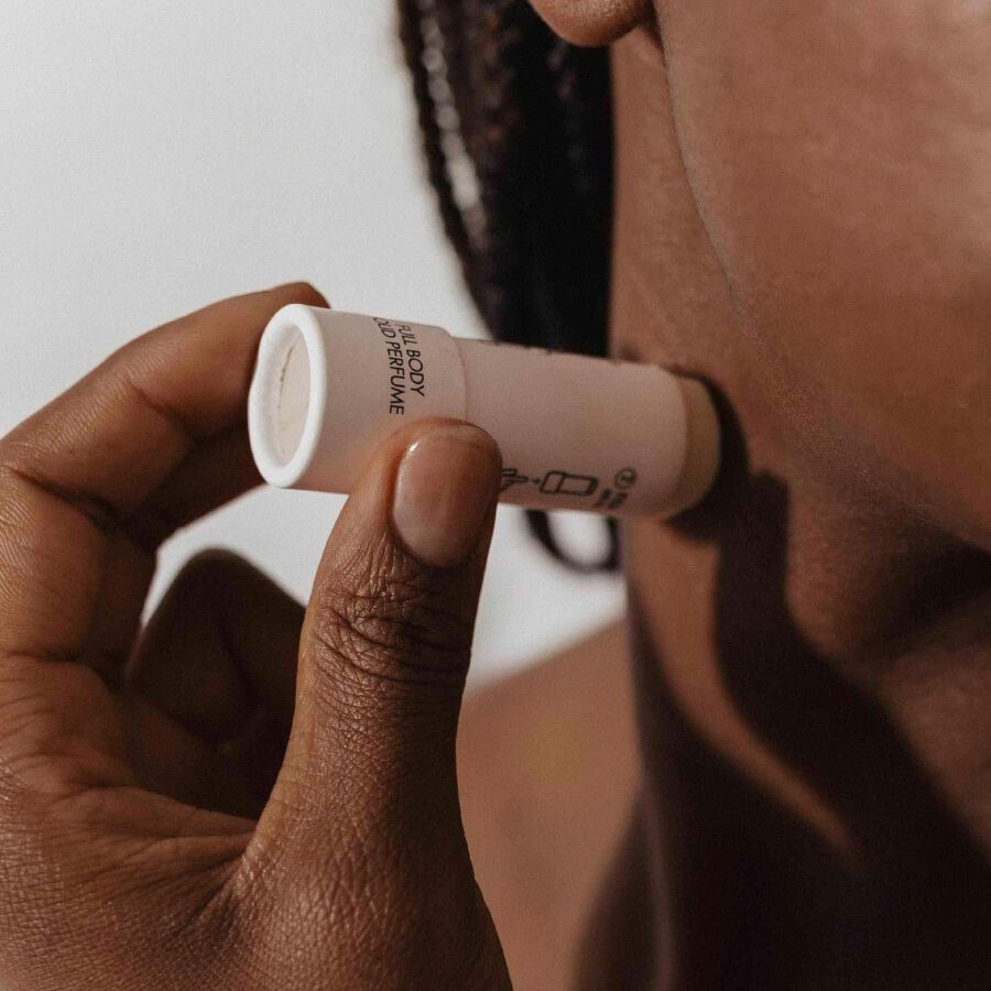 Mano che applica Bijoux Indiscrets SLOW SEX Profumo solido per tutto il corpo sulla pelle.