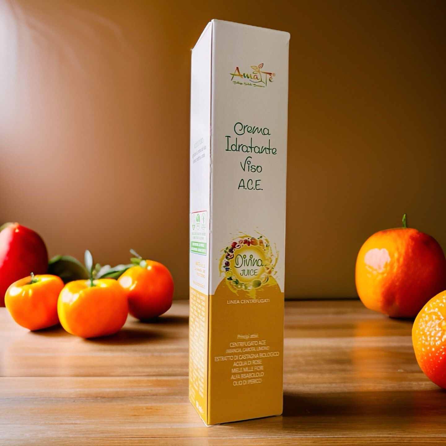 Confezione allungata con nome e logo del prodotto. Scritta: Crema Idratante Viso A.C.E. Divina Juice. Arance e limoni su fondo in legno.