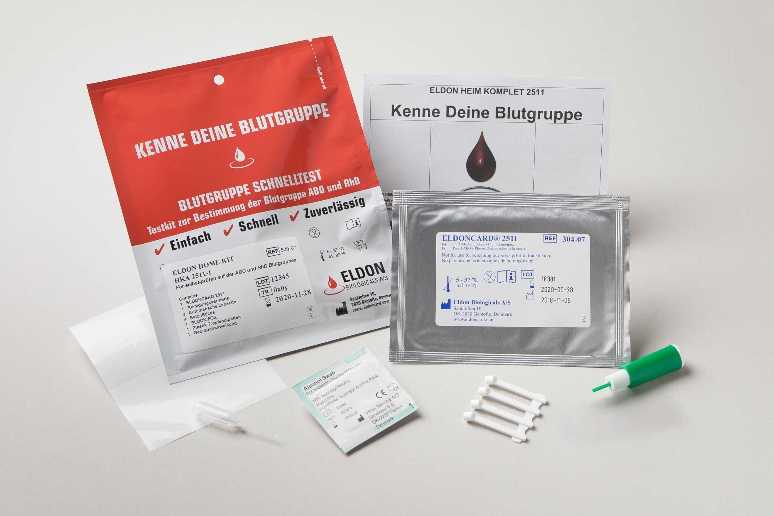 Kit per test del gruppo sanguigno. Confezioni rosse e argentate, schede di test, lancetta, istruzioni. Testo: Eldon, gruppo sanguigno, test rapido.