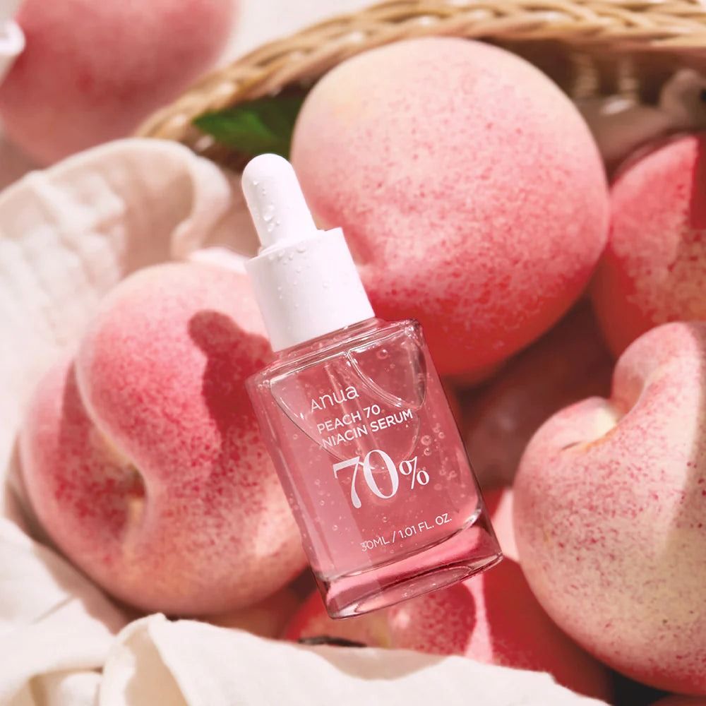 Flacone di vetro con siero, circondato da pesche. Scritta: Anua, PEACH 70 Niacin Serum, 70%. 30 ml / 1.01 fl.oz.