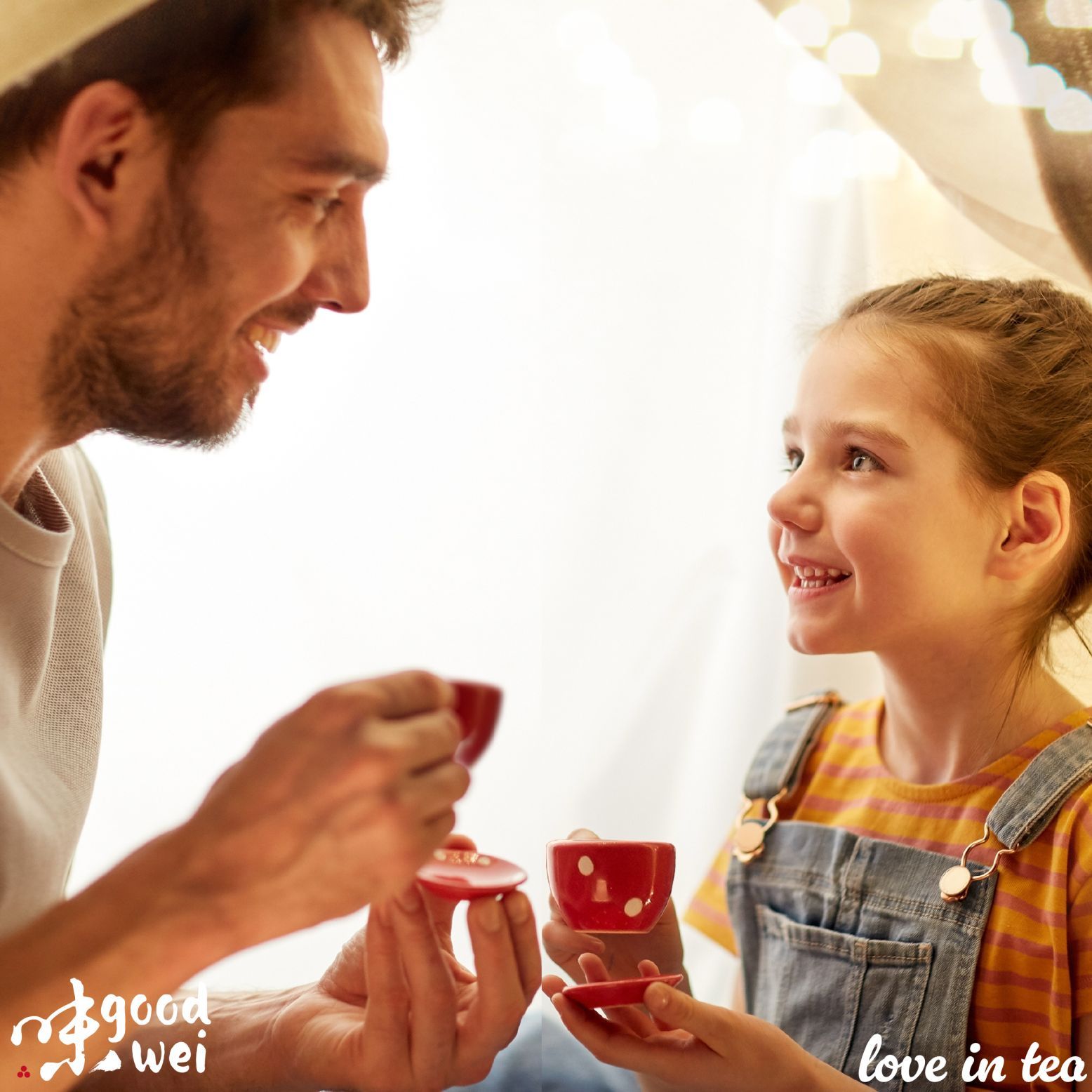 Un uomo e una ragazza bevono tè da tazze rosse. Logo Goodwei e scritta 'love in tea'.
