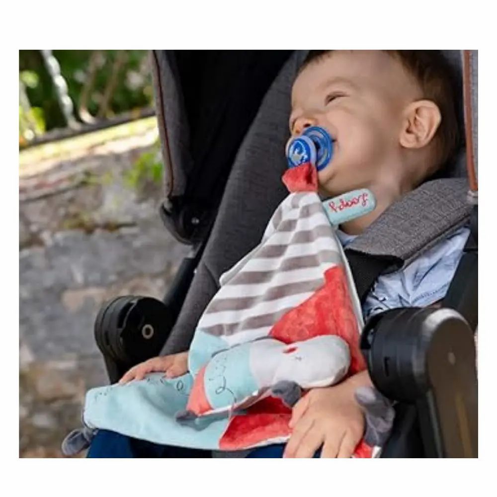 Bambino in passeggino con doudou e ciuccio. Tessuto a righe, testa di ippopotamo.