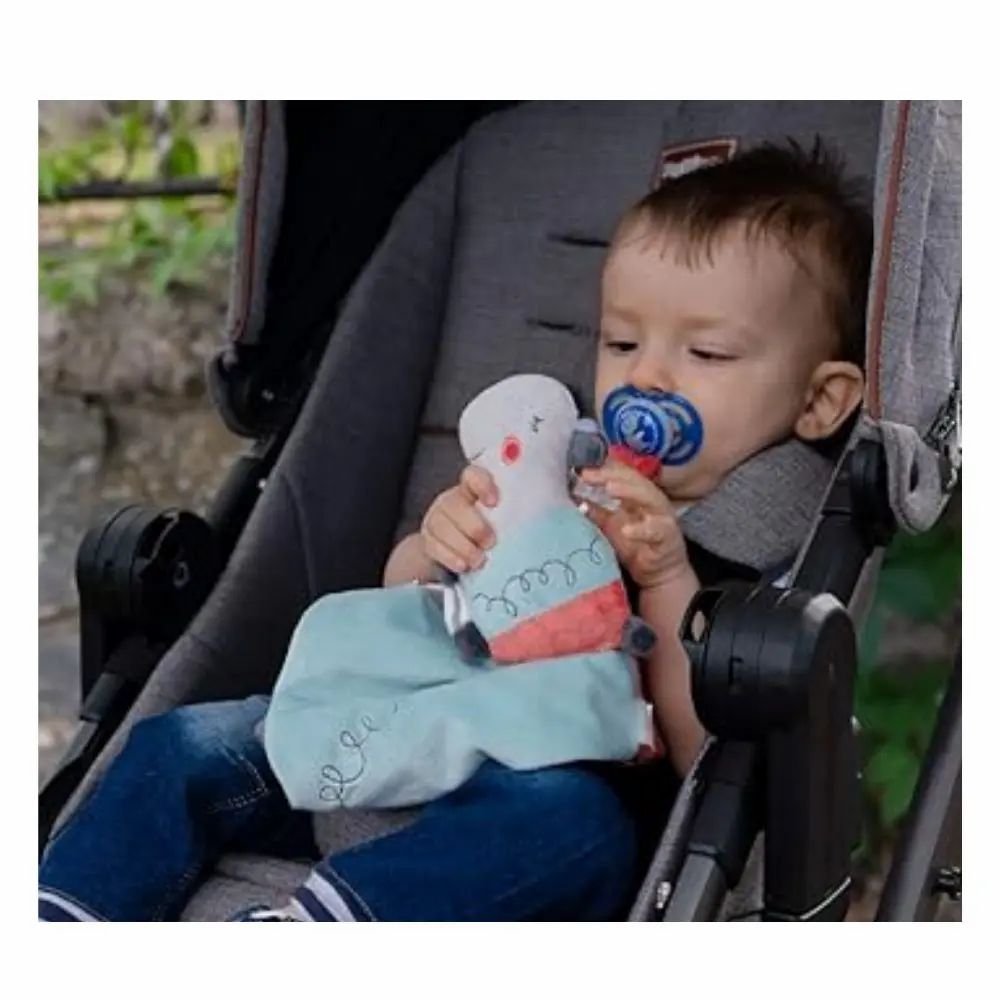Bambino in passeggino con doudou e ciuccio. Tessuto blu, testa di ippopotamo.