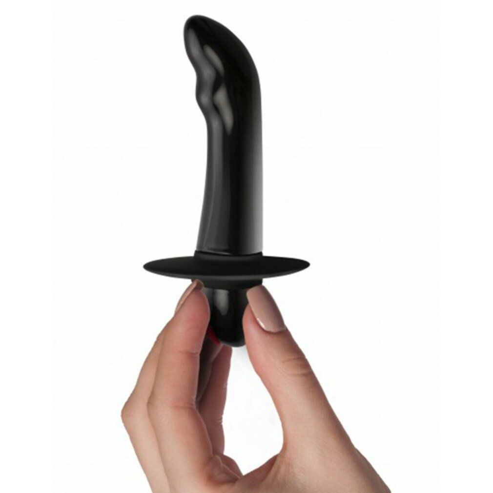 Vibratore nero tenuto da una mano. Forma curva, base ampia, pulsante rosso.