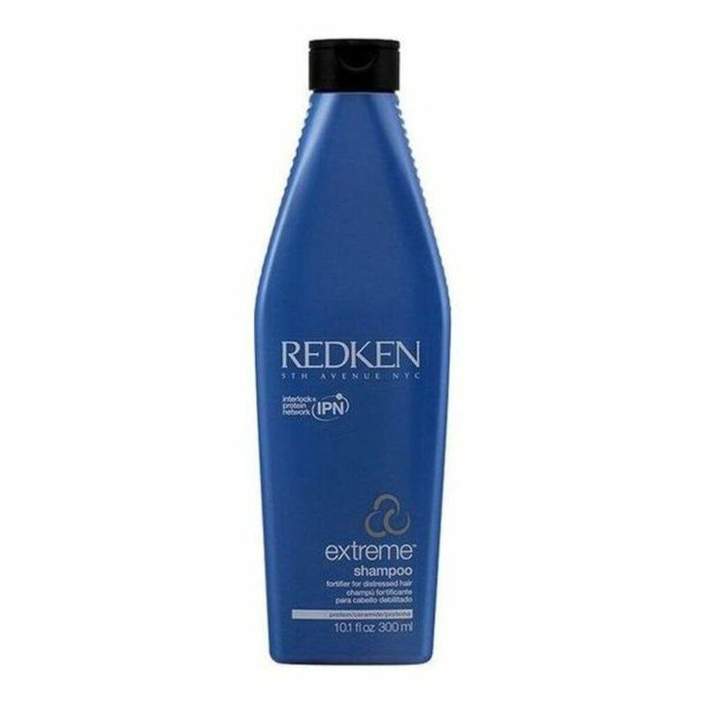Flacone di shampoo blu con tappo nero. Scritta: Redken Extreme Shampoo. Contiene IPN. Per capelli danneggiati.