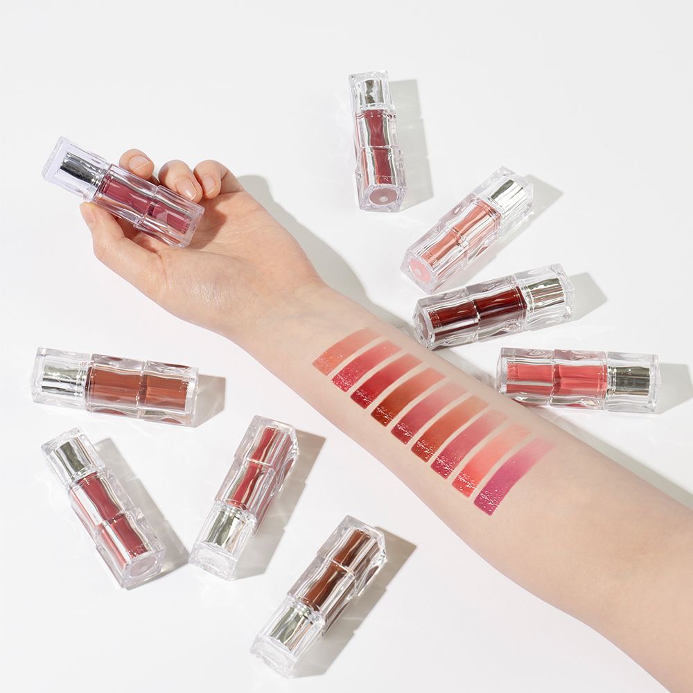 Mano con swatch di TIRTIR Waterism Glow Tint applicati, circondata da boccette.