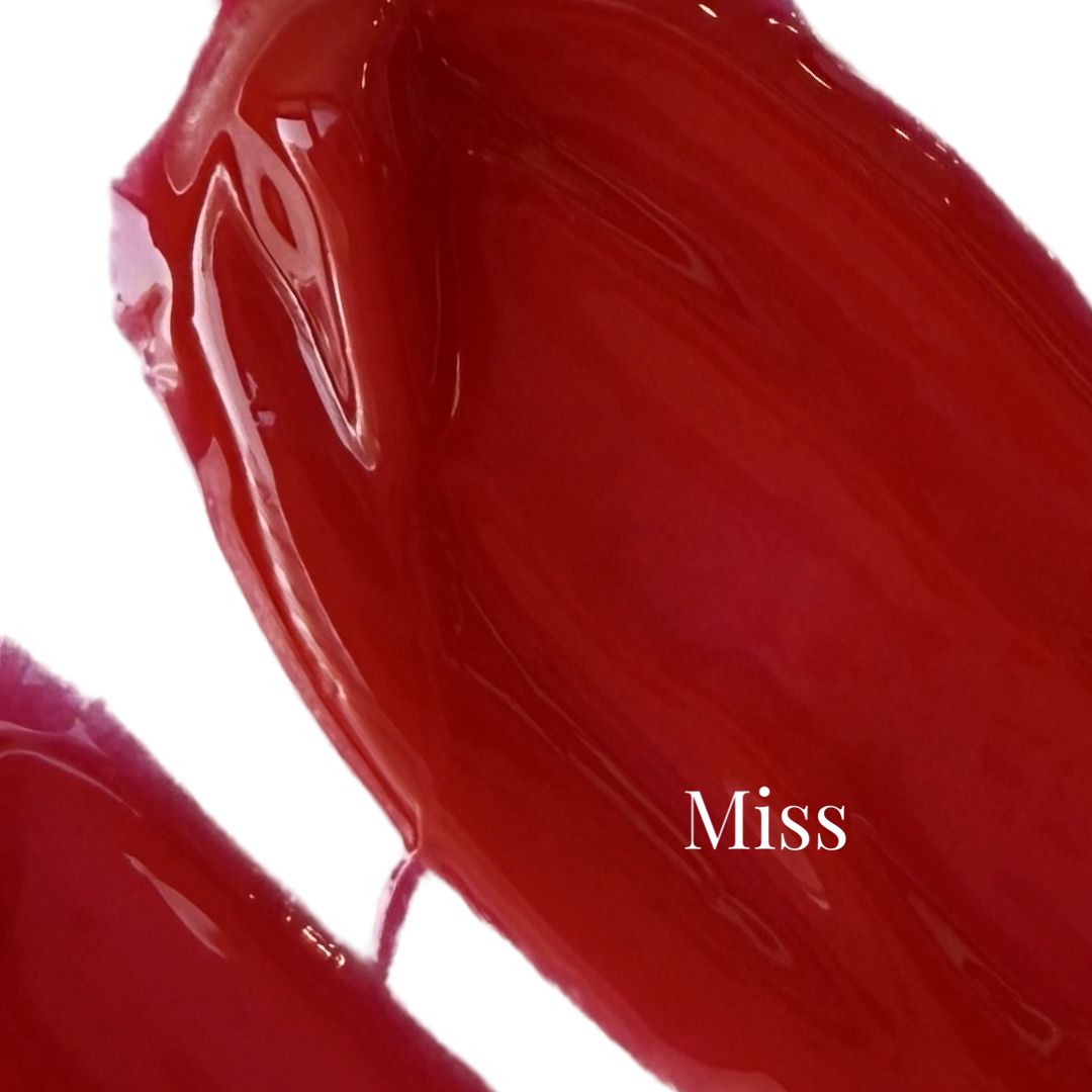 Primo piano di una striscia di lucidalabbra rosso. Scritta: Miss.