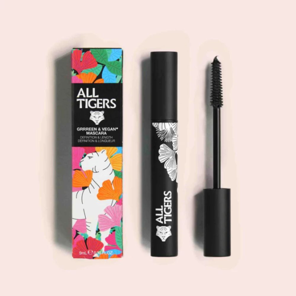 Mascara con confezione. Tubo nero con logo e design a foglie. Confezione con logo, foglie e testo.