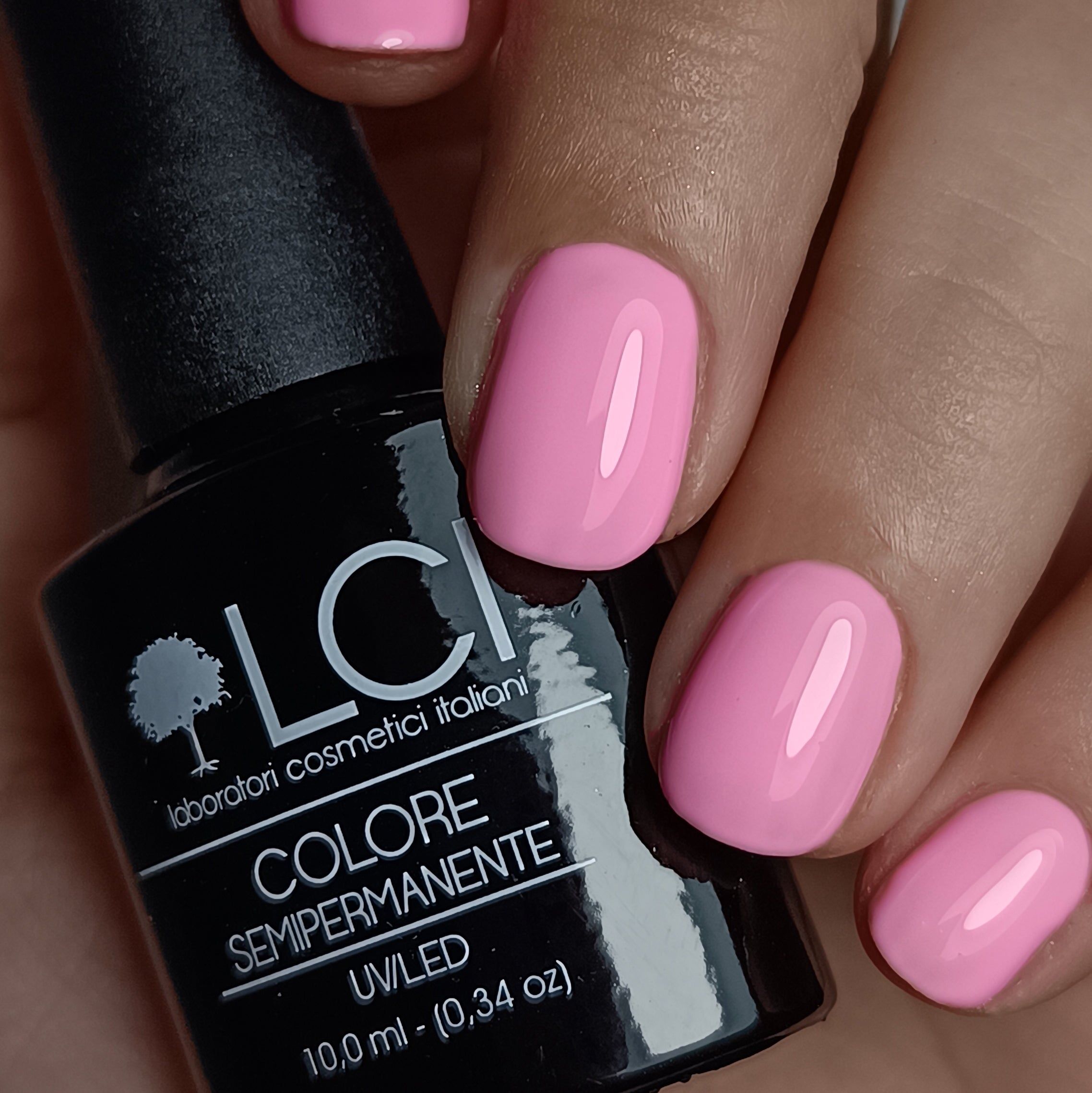 Mani con unghie rosa smaltate. Accanto, flacone di smalto con scritta: LCI, Colore Semipermanente, UV/LED, 10,0 ml.