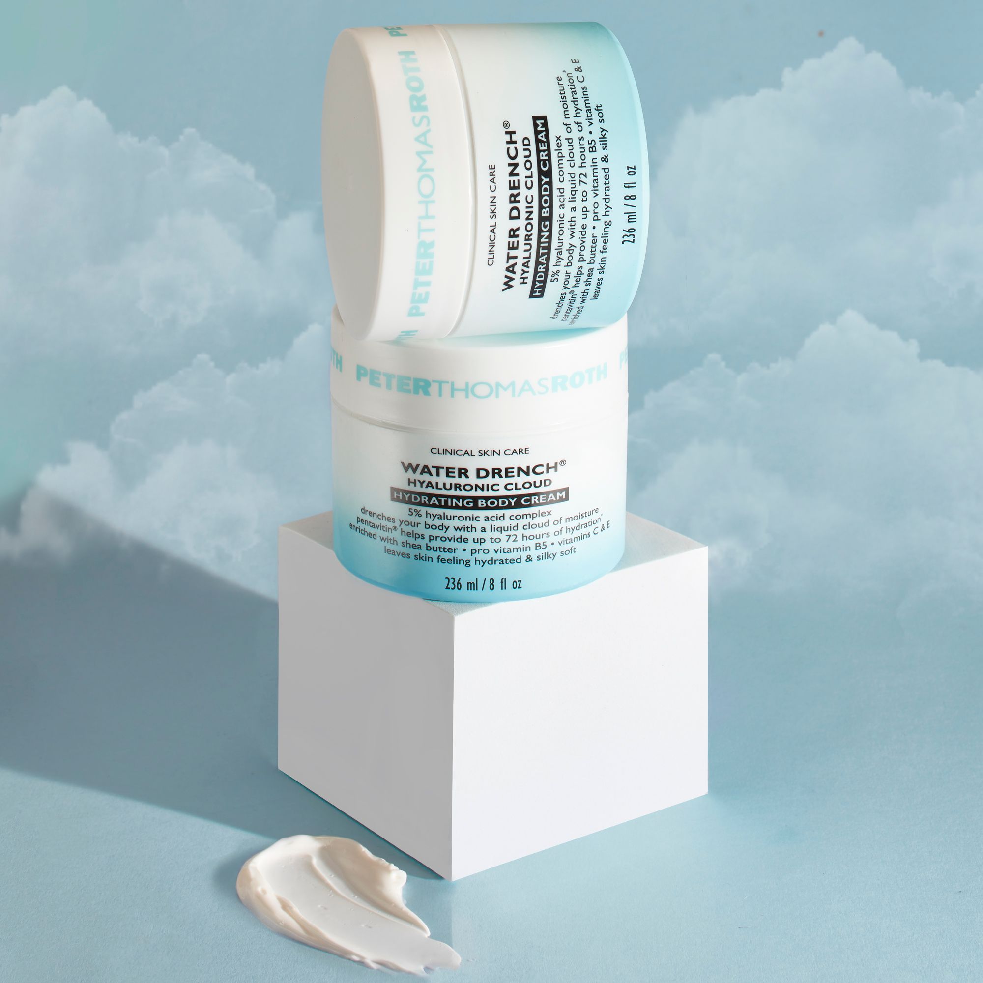 Due barattoli di crema impilati. Scritta: Water Drench Hyaluronic Cloud Hydrating Body Cream. Sfondo: piedistallo bianco, crema.