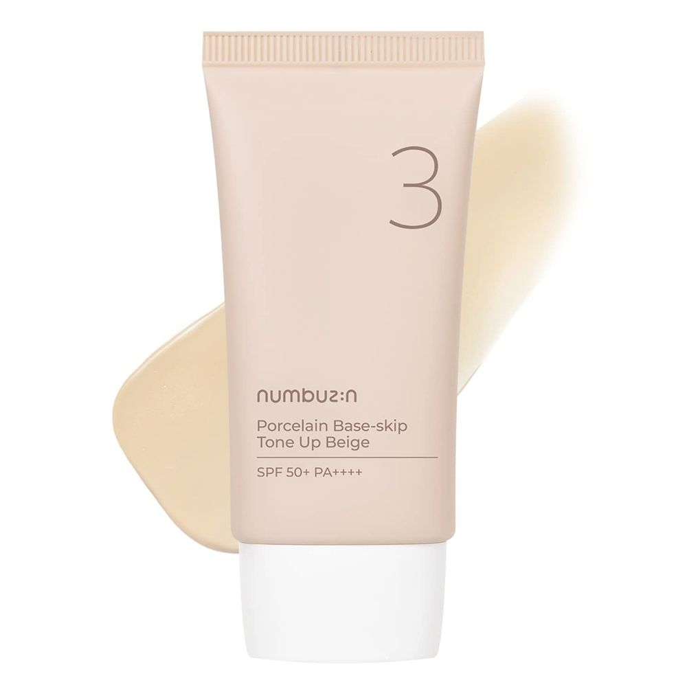 Tubo beige con tappo bianco e striscia di crema. Scritta: n:umbuz:in, Porcelain Base-skip, Tone Up Beige, SPF 50+ PA++++. Numero 3.