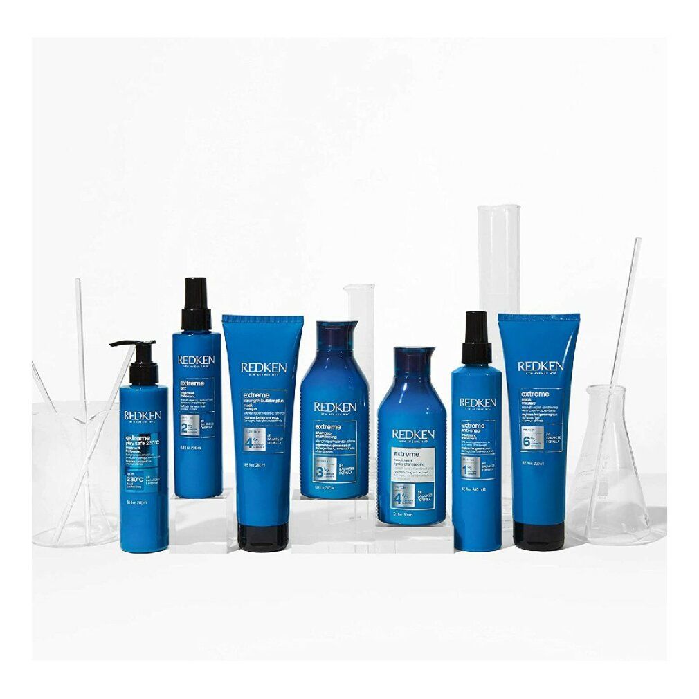 Vari prodotti per capelli Redken blu. Flaconi, tubi, spray. Scritte: extreme, 2, 3, 5, 6.