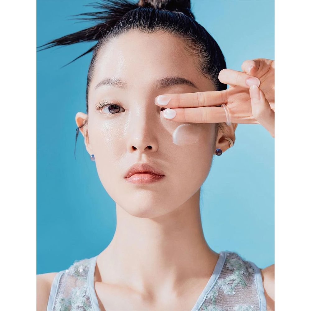 Donna applica crema solare sul viso. Prodotto non identificabile.