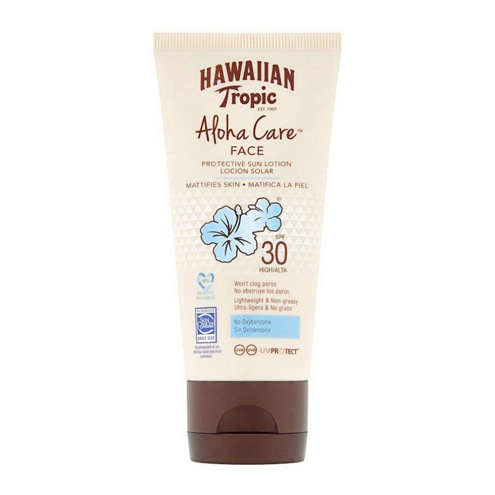 Tubo di lozione solare con tappo marrone. Scritta: Hawaiian Tropic Aloha Care Face SPF30. Fiore blu e testo.