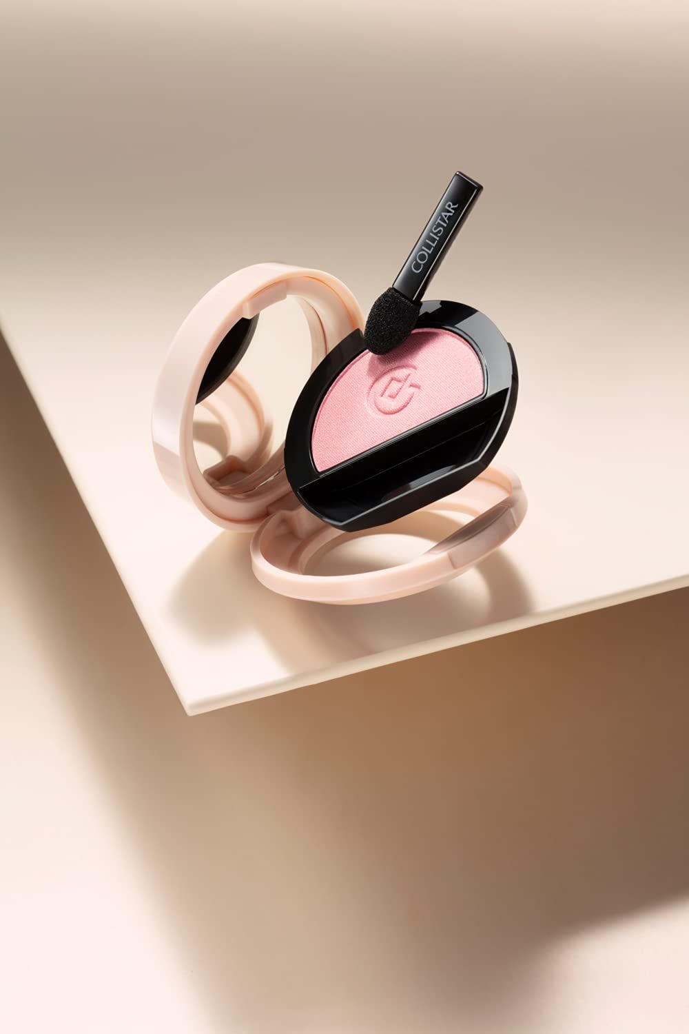 Ombretto rosa satinato in confezione rotonda aperta. Applicatore nero. Marchio Collistar.