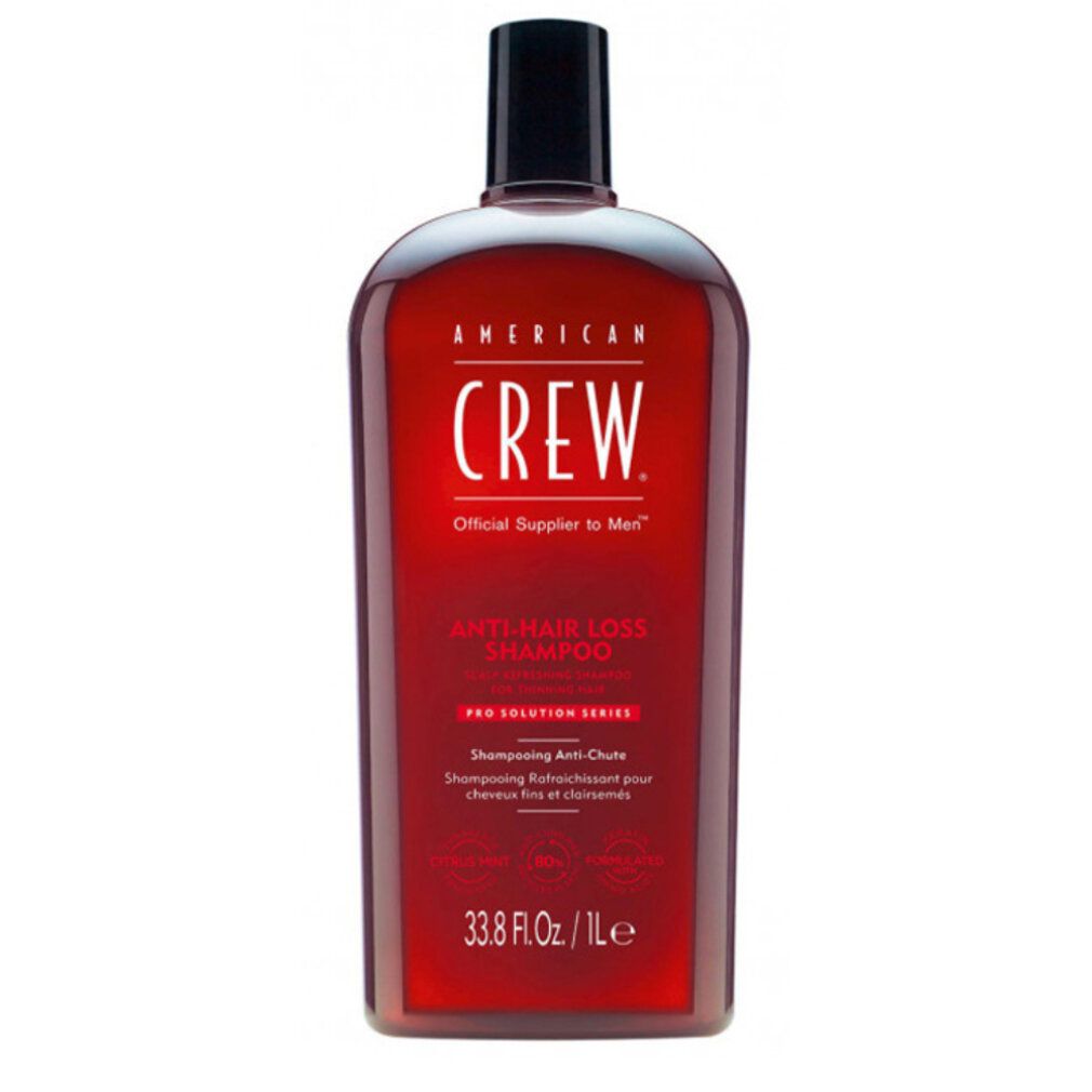 Flacone di shampoo rosso con tappo nero. Scritta: AMERICAN CREW. Testo: Shampoo Anti-Caduta. 33.8 Fl. Oz. / 1L.