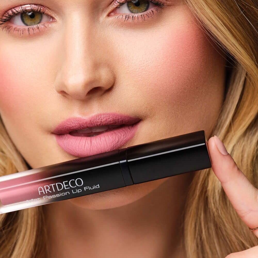 Donna tiene Artdeco Mat Passion Lip Fluid. Rossetto applicato sulle labbra. Testo: Artdeco Mat Passion Lip Fluid.