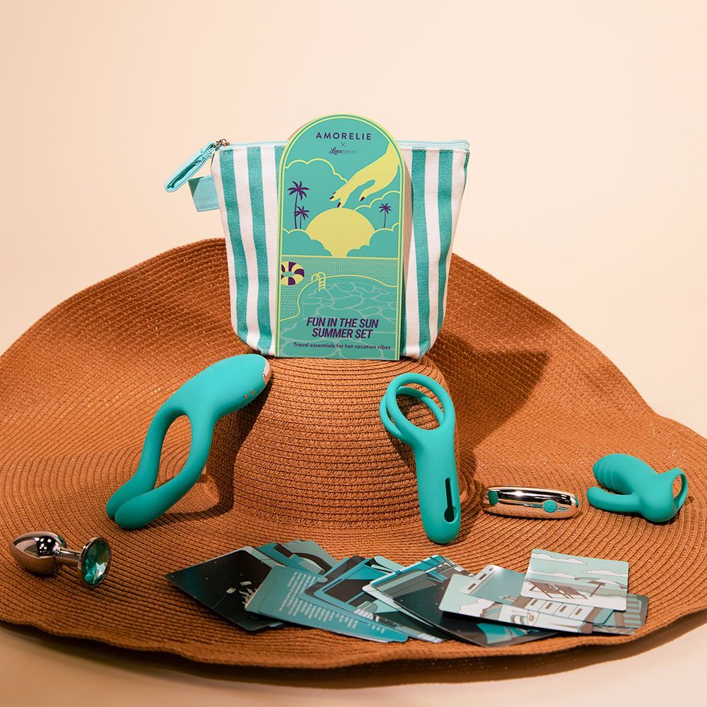 Set di sex toys turchesi su un cappello da sole. Include vibratore doppio, plug anale, vibratore, vibratore ad anello, carte e borsa da spiaggia.