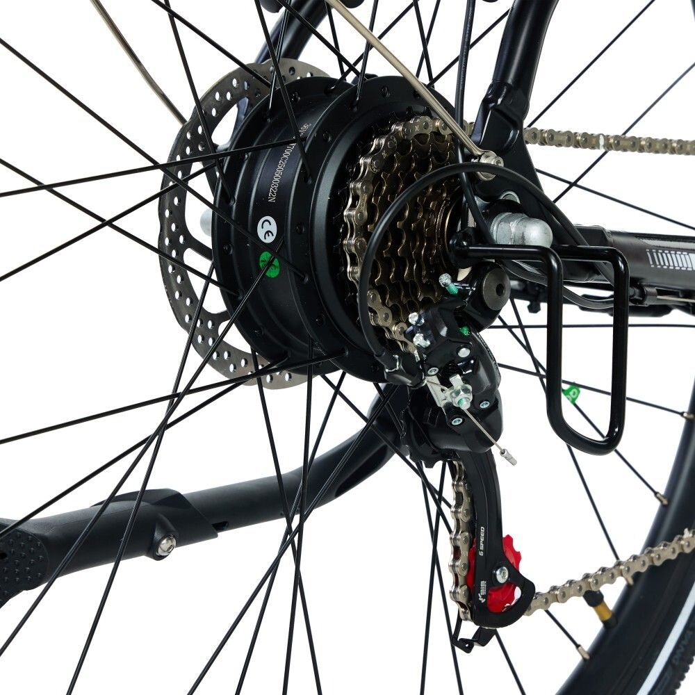 Primo piano della ruota posteriore di una bicicletta elettrica. Sono visibili ingranaggi, disco freno, catena e portapacchi.