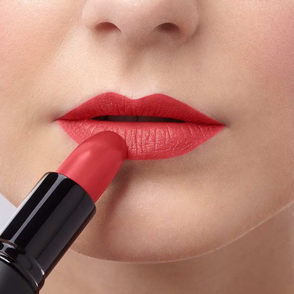 Labbra che vengono truccate con un rossetto rosso. Il rossetto è visibile.