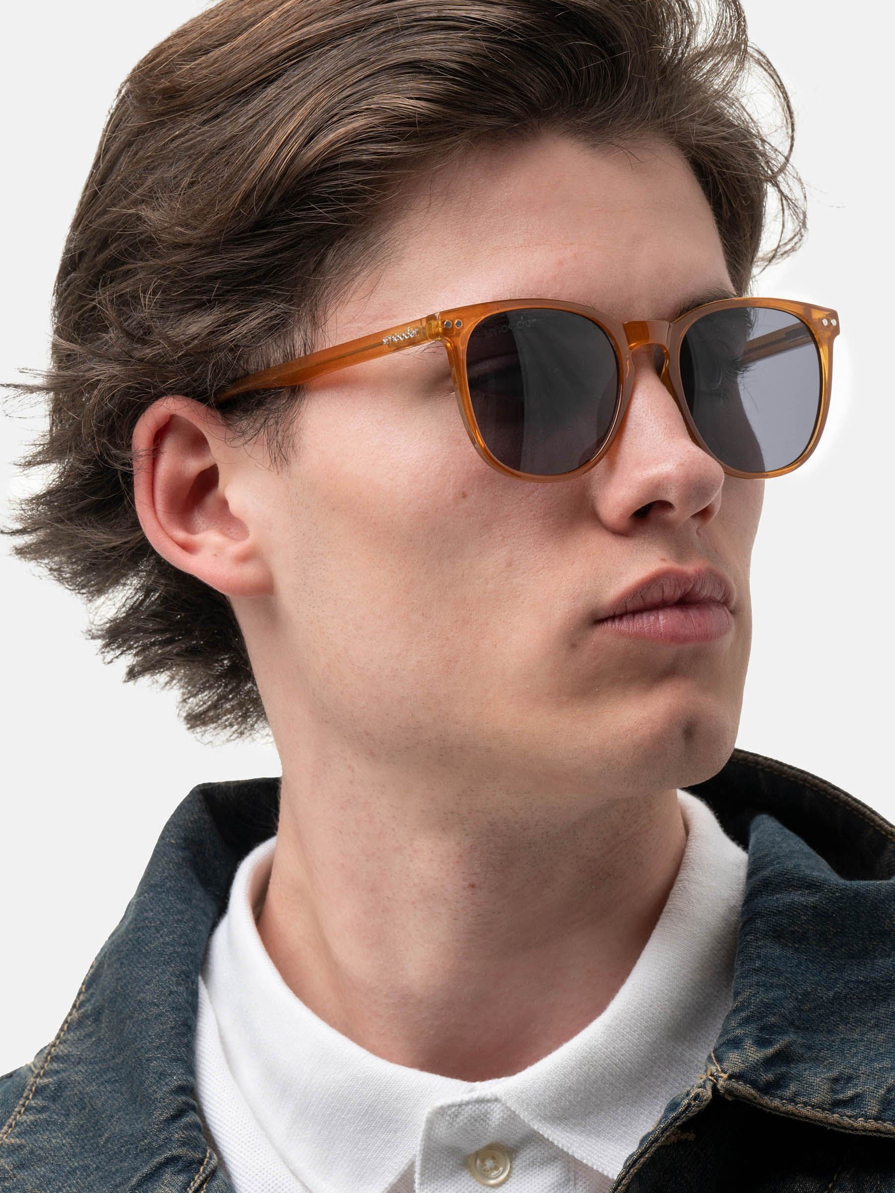 Uomo con occhiali da sole marroni e lenti scure. Il logo 'smooder' è visibile.