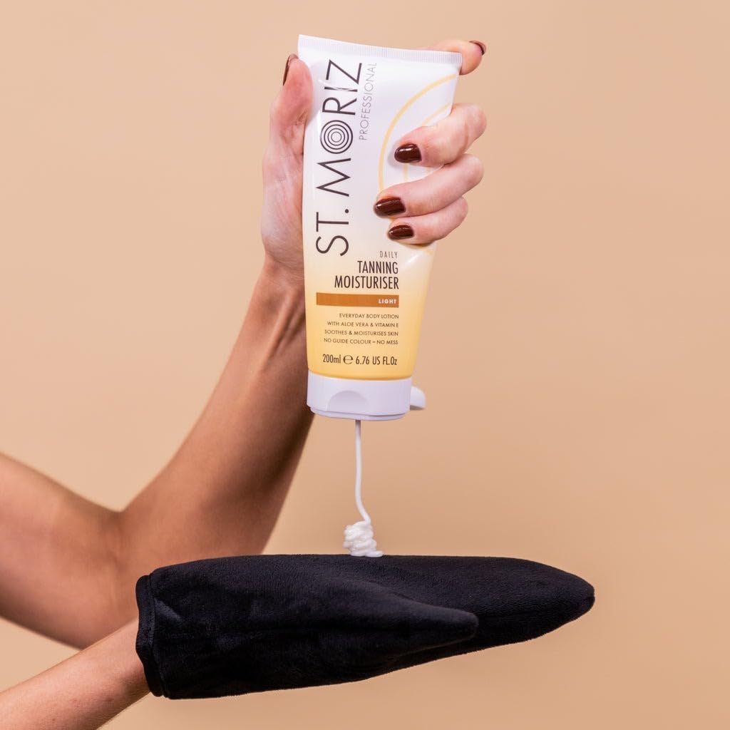 Persona tiene lozione St. Moriz. Crema applicata su applicatore nero. Scritta: Daily Tanning Moisturiser.