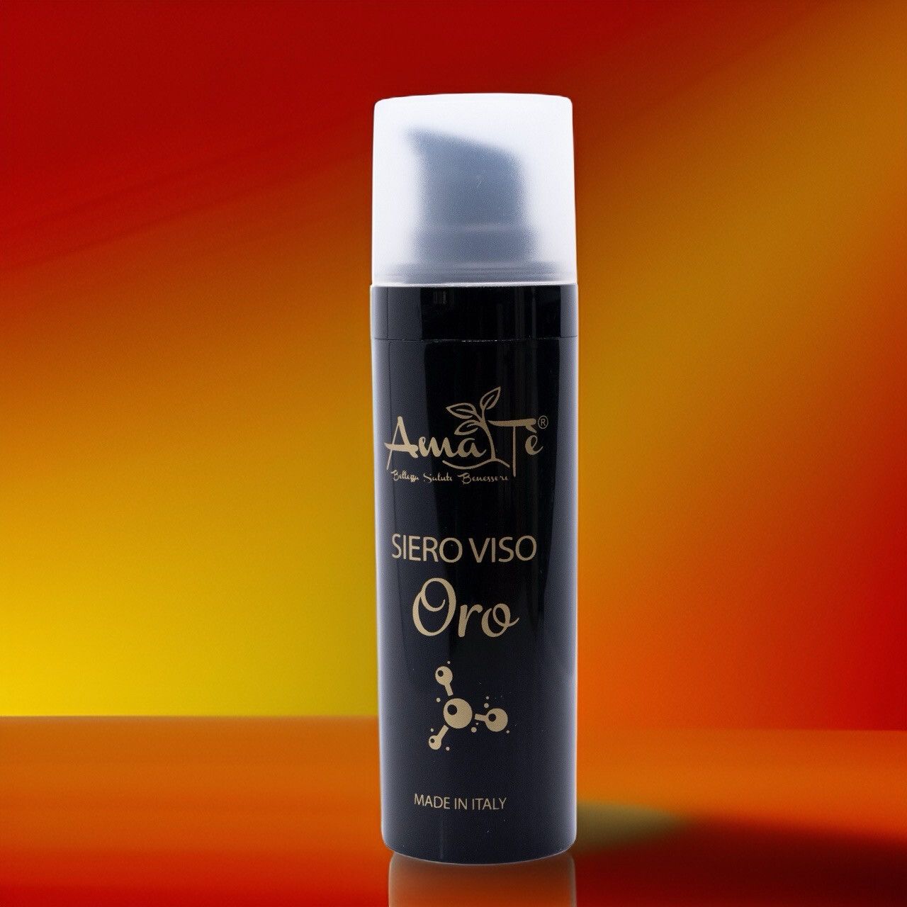 Flacone nero con tappo bianco. Scritta: Amatè Siero Viso Oro. Prodotto in Italia. Sfondo rosso-arancio.
