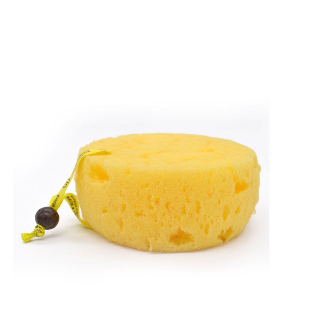 Spugna da bagno rotonda gialla con nastro giallo e perla di legno. La spugna è piatta e rotonda.