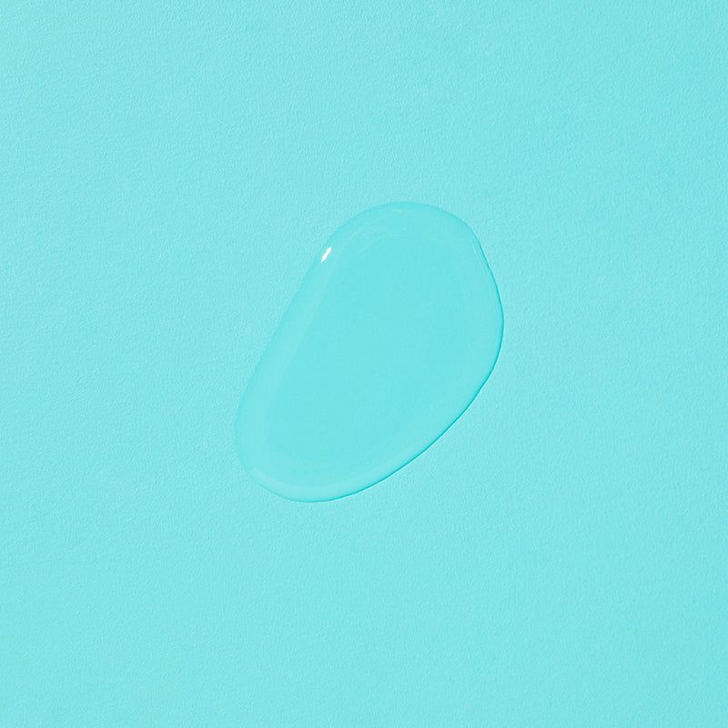 Goccia di liquido trasparente su sfondo azzurro. Forma arrotondata.
