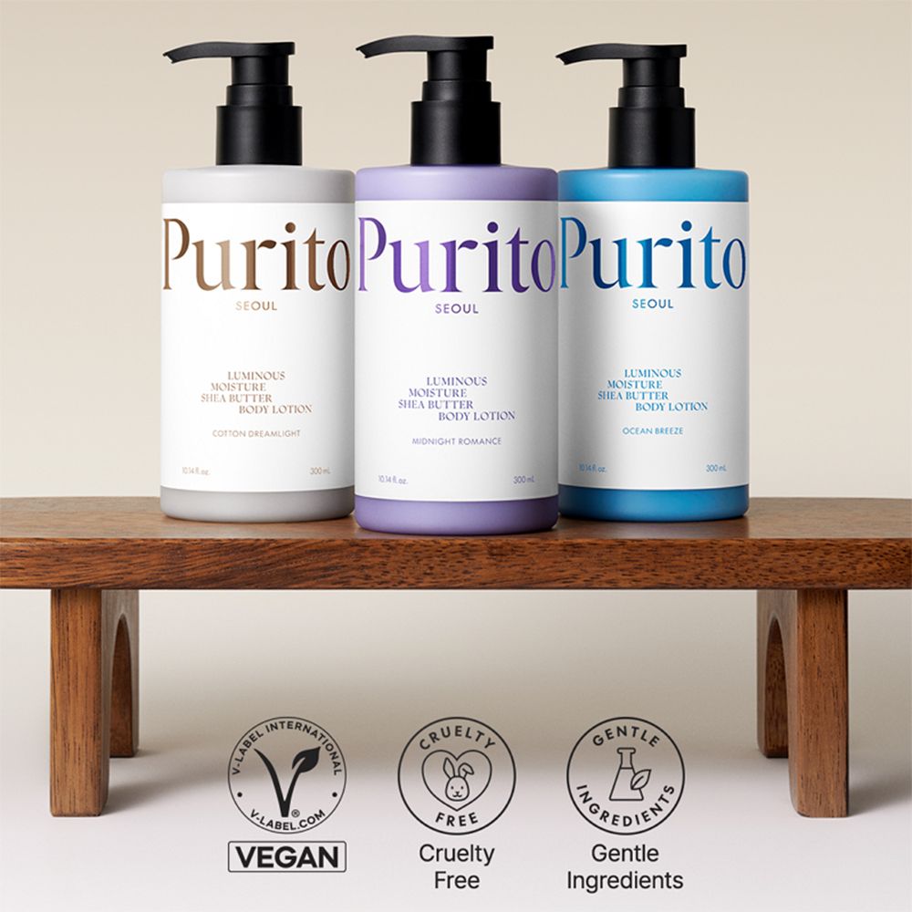 Tre flaconi di lozione su legno. Colori: grigio, viola, blu. Scritta: Purito Seoul, Luminous Moisture Shea Butter Body Lotion. Vegan, Cruelty Free, Gentle Ingredients.