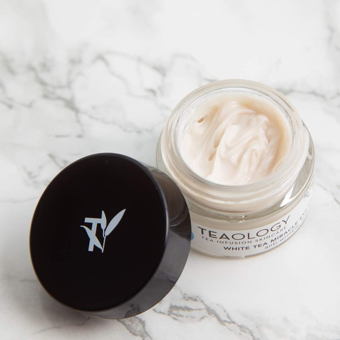 Crema in un barattolo di vetro con coperchio aperto. L'etichetta riporta "Teaology" e "White Tea Miracle Anti-Age Cream".