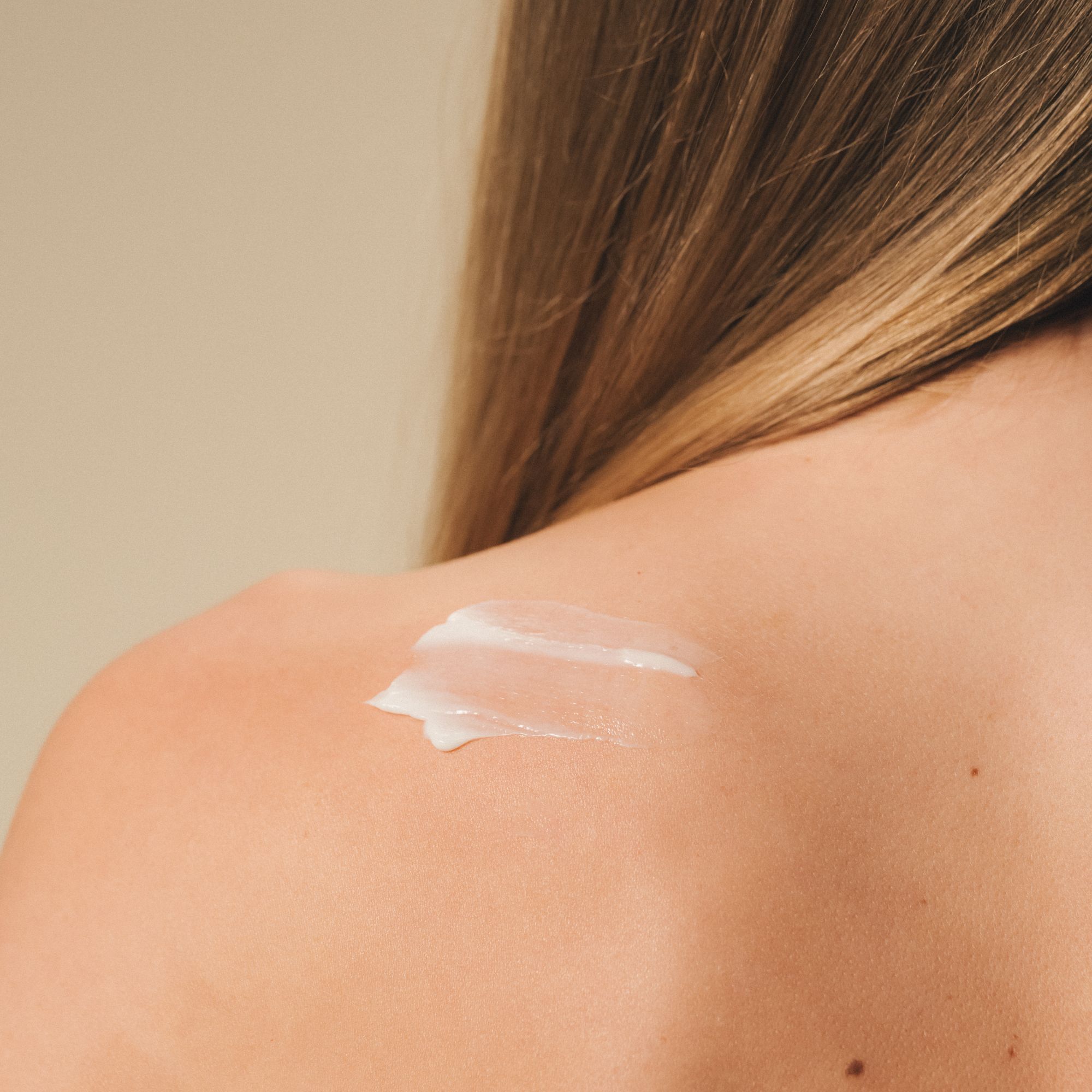 Una crema bianca sulla spalla di una persona.