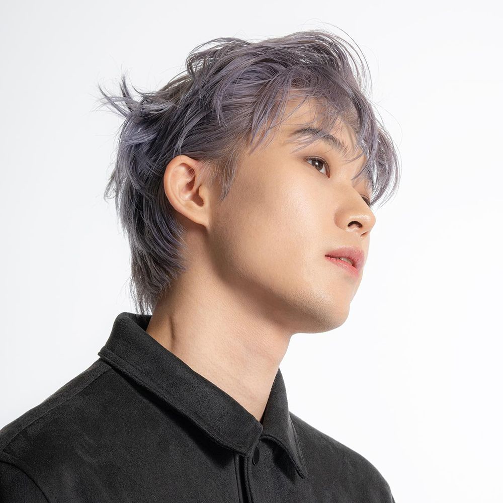 Ritratto di un uomo con capelli grigi. Guarda di lato. Camicia nera.