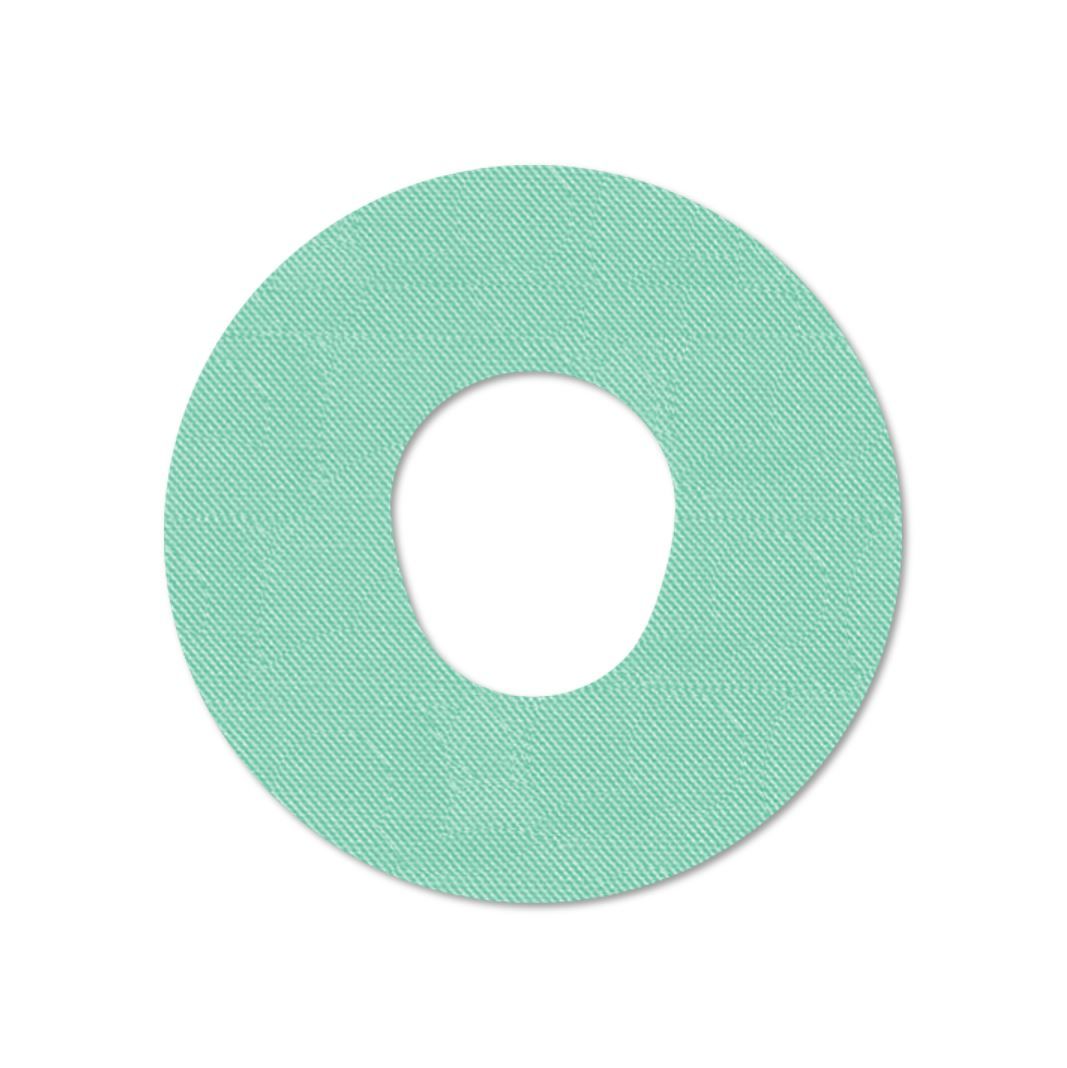 Cerotto di fissaggio rotondo verde chiaro con foro centrale. Tessuto.