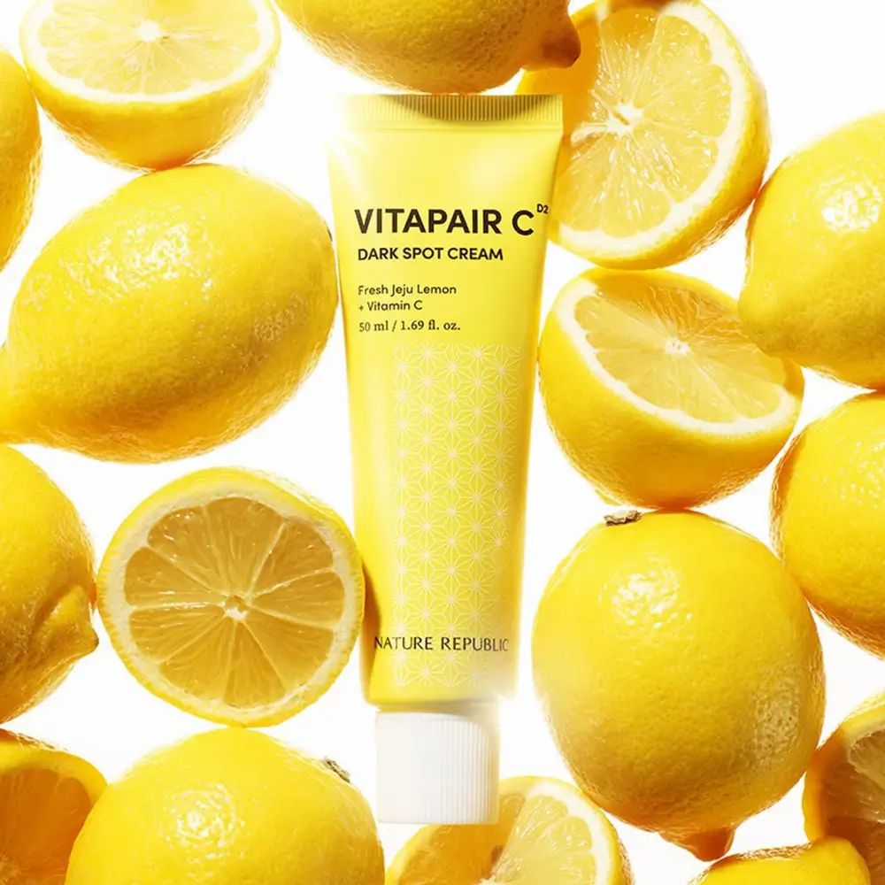 Tubo giallo con tappo bianco, circondato da limoni. Scritta: Vitapair C Dark Spot Cream. Marchio: NATURE REPUBLIC.