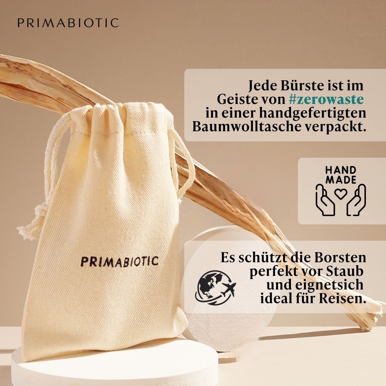 Spazzola per massaggio viso con manico in legno e setole, accanto a un sacchetto. PRIMABIOTIC sul sacchetto. Testo: Ogni spazzola è confezionata in un sacchetto di cotone.