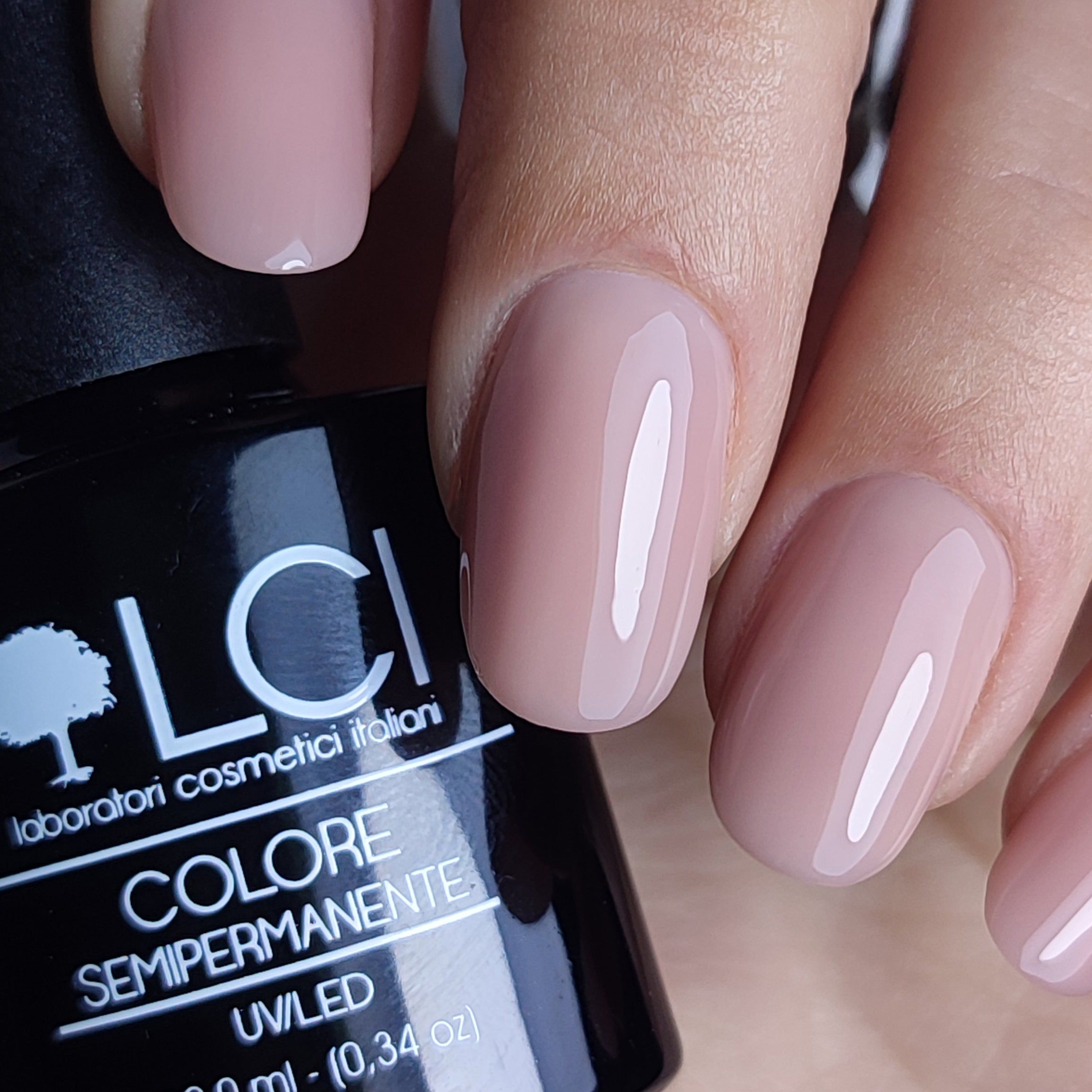 Unghie con smalto semipermanente Nude Armonia. Flacone LCI sullo sfondo.