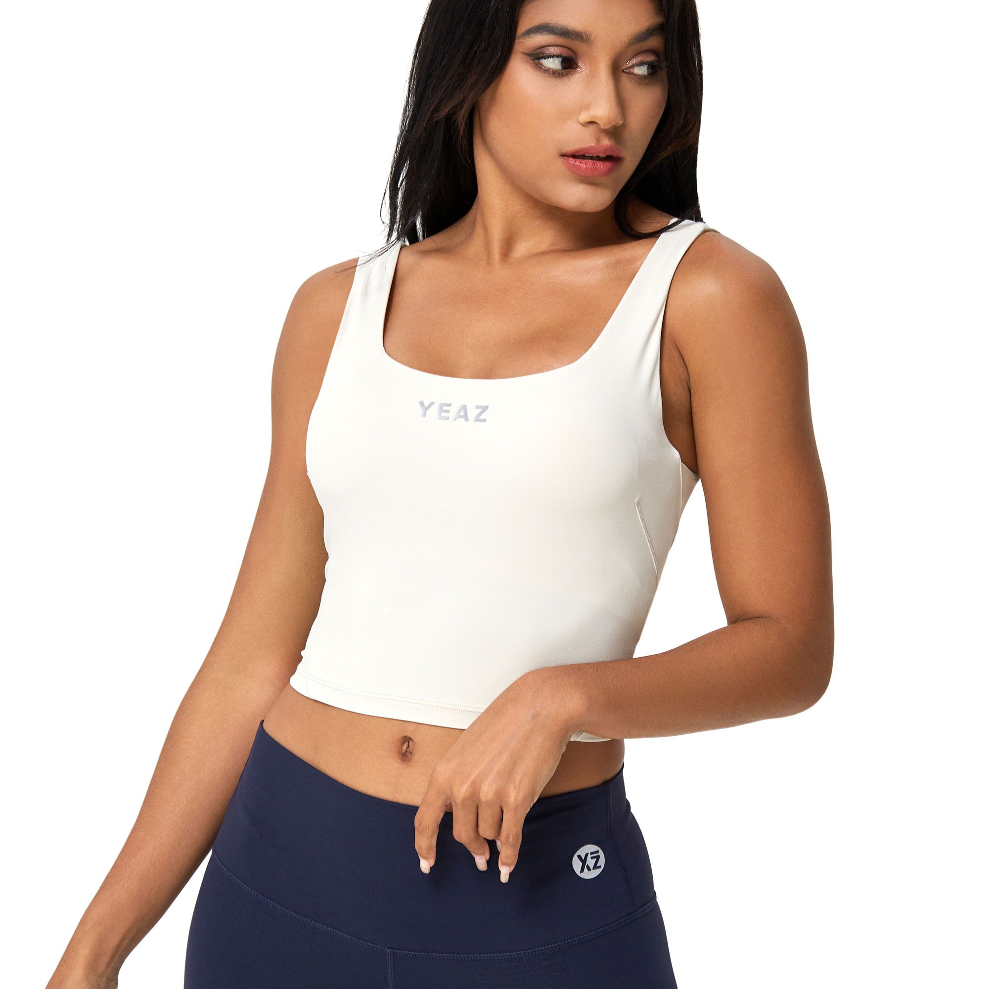 Crop top bianco senza maniche con scollo quadrato e discreto logo "YEAZ" sul petto.