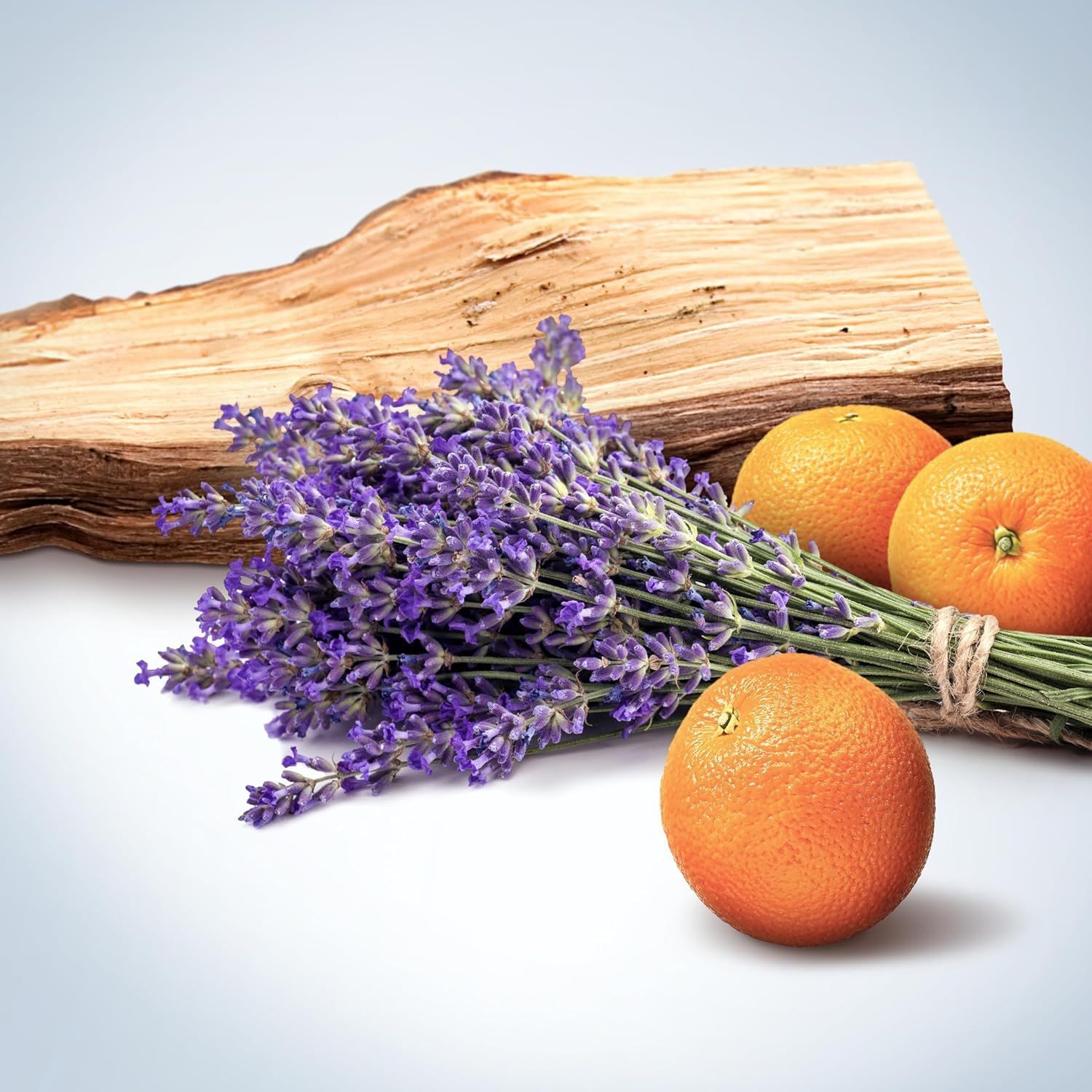Lavanda, arance e pezzo di legno. Arance legate con spago. Sfondo chiaro.