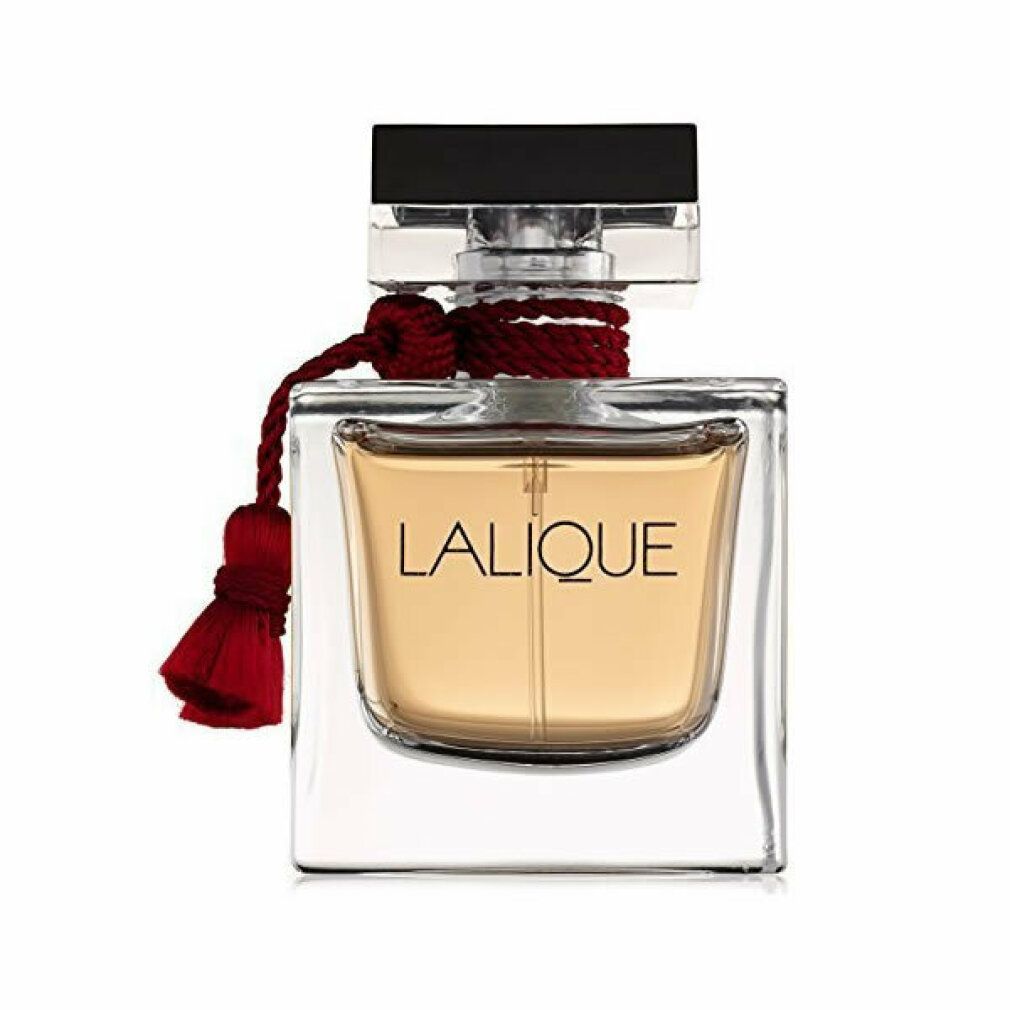 Flacone quadrato in vetro con liquido dorato. Tappo nero, filo e nappa rossi. Scritta: LALIQUE.
