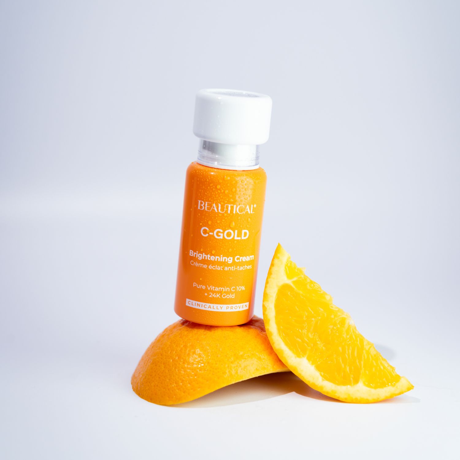 Flacone e fetta d'arancia. Scritta: BEAUTICAL C-GOLD Brightening Cream.