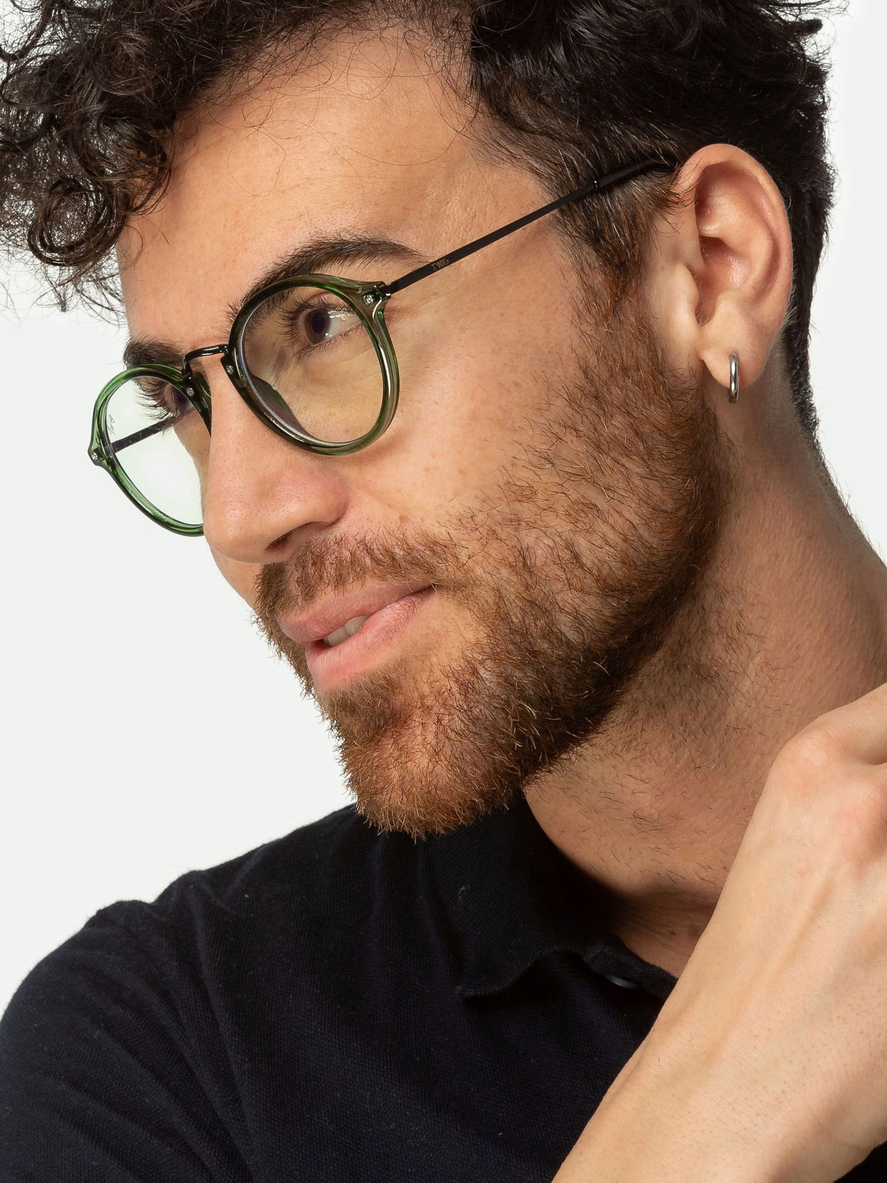 Uomo con occhiali verdi. Montatura nera. Marchio Twig.