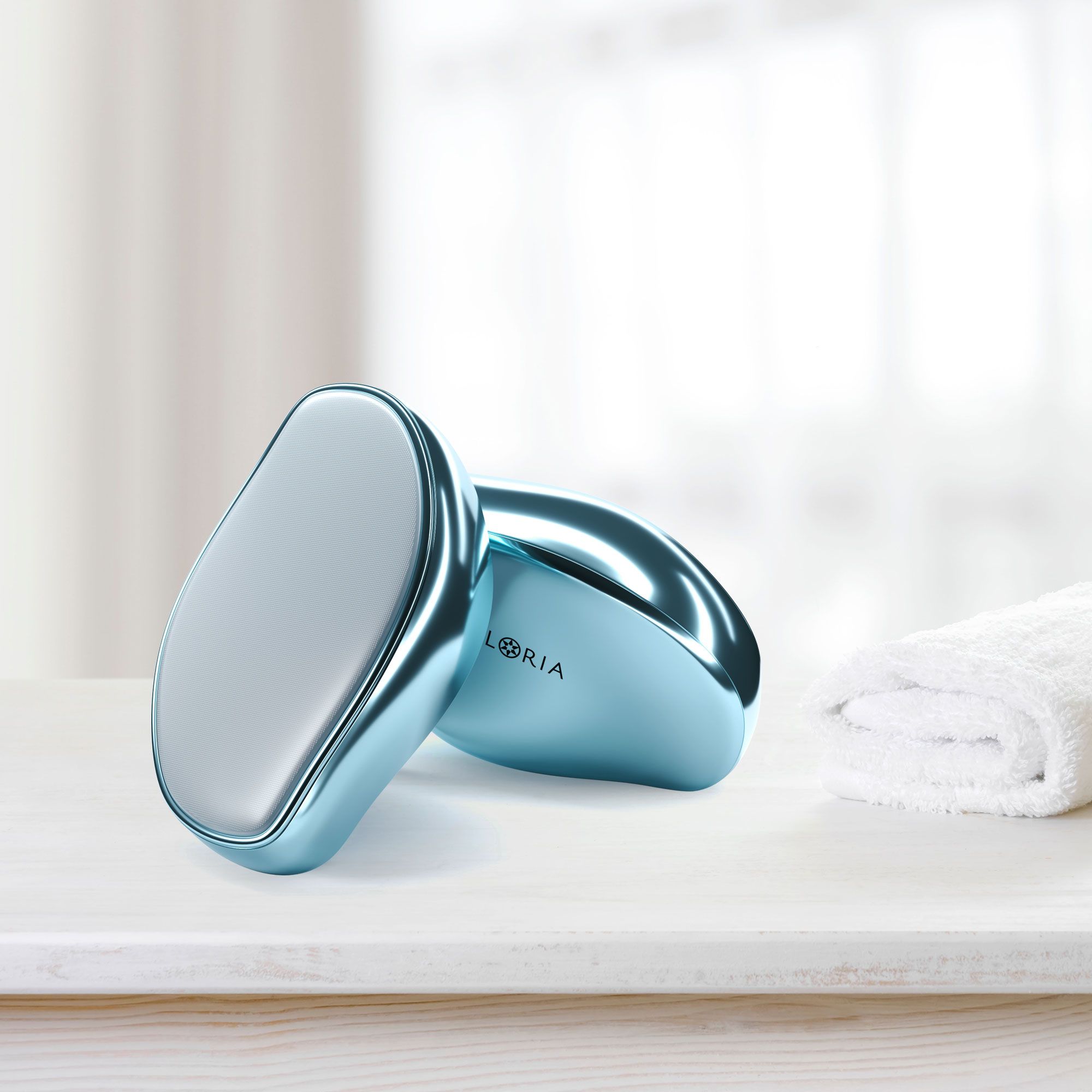 Due epilatori blu in nano-vetro su una superficie bianca. Un asciugamano bianco è accanto.