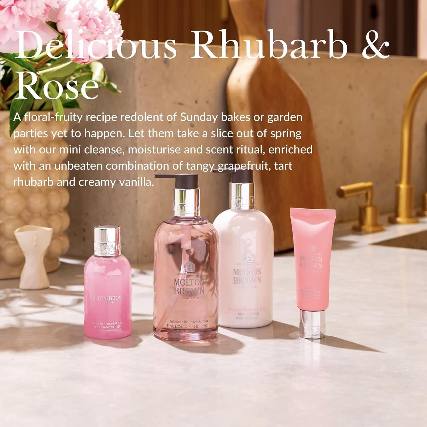 Vari prodotti rosa. Flaconi e tubetto con nomi di prodotti. Sfondo: cucina con fiori.